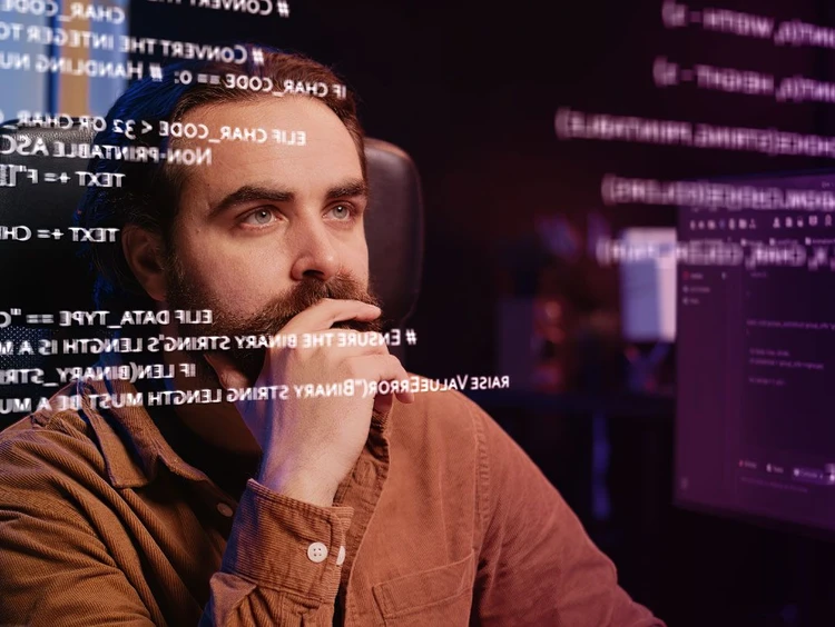 Developer looks carefully at a virtual board with strings of code