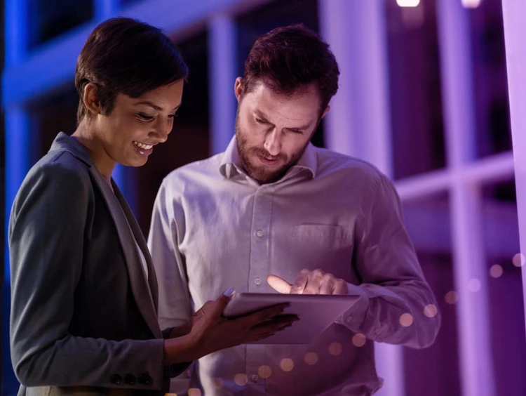 Two colleagues collaborate using a tablet