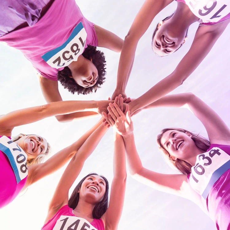 A group of girls with numbered bibs joined hands and strengthened each other in a sense of solidarity and wellness.