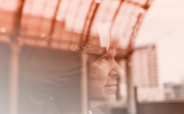 Close-up side view of a businessman in a suit and tie looking out of a window, symbolising strategy and vision.