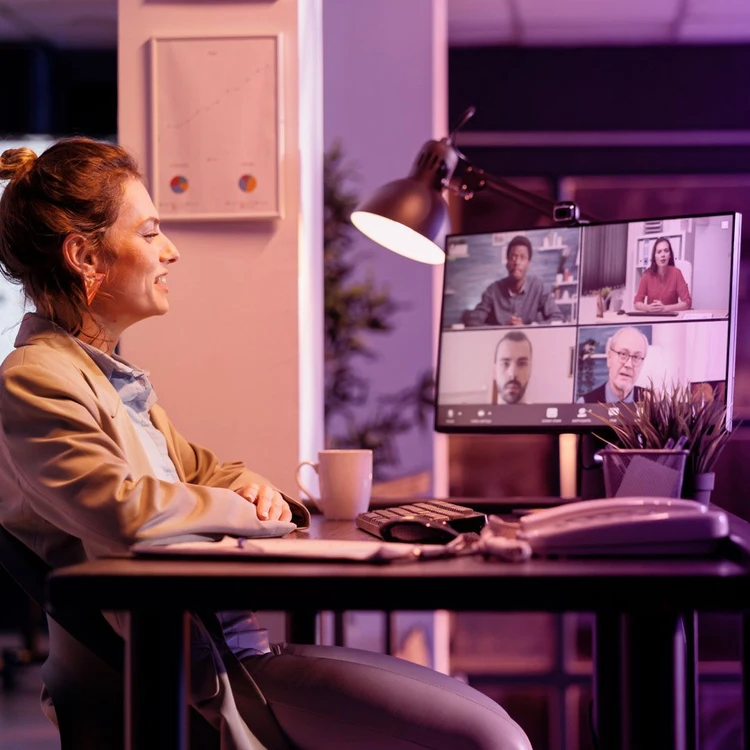 Group of colleagues working in hybrid mode, connecting by video call on PC.