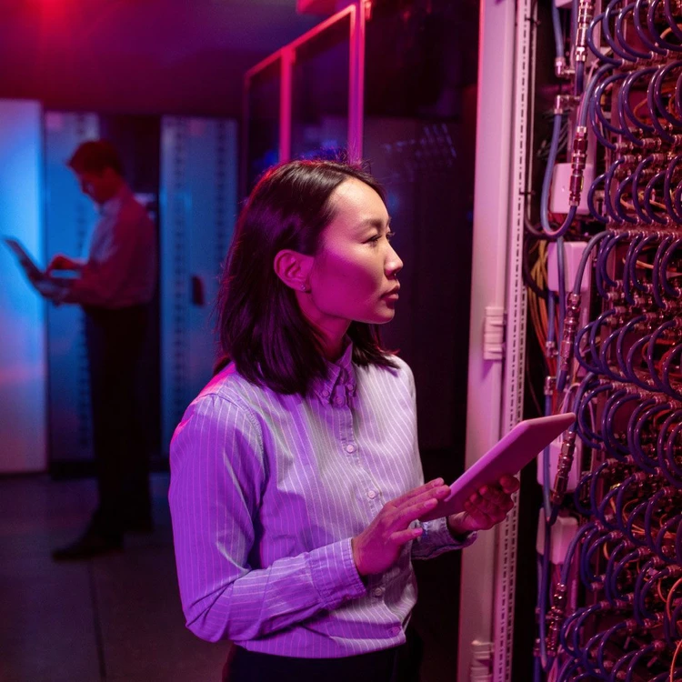 Professional checks cables, doing analysis with his tablet.