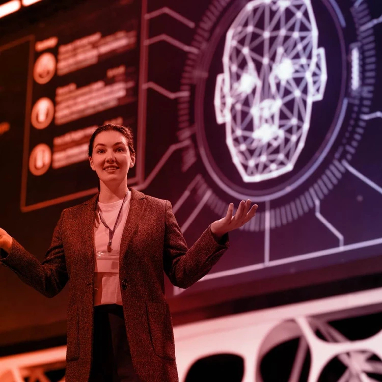 A woman on stage explains the process of mapping internal processes and regulations.